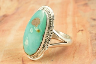 Genuine Boulder Turquoise set in Sterling Silver Ring. The cabachons are of Boulder Turquoise, you can see the veins of Turquoise running through the host rock. The Boulder Turquoise Mine is located in northeast Nevada. It was discovered in 1970 by a Shoshone sheep herder. Production is small due to the remote location and winter weather. Boulder Turquoise is valued for both it's beauty and rarity. Every stone is unique. Created by Navajo Artist Larson Lee. Signed. 
